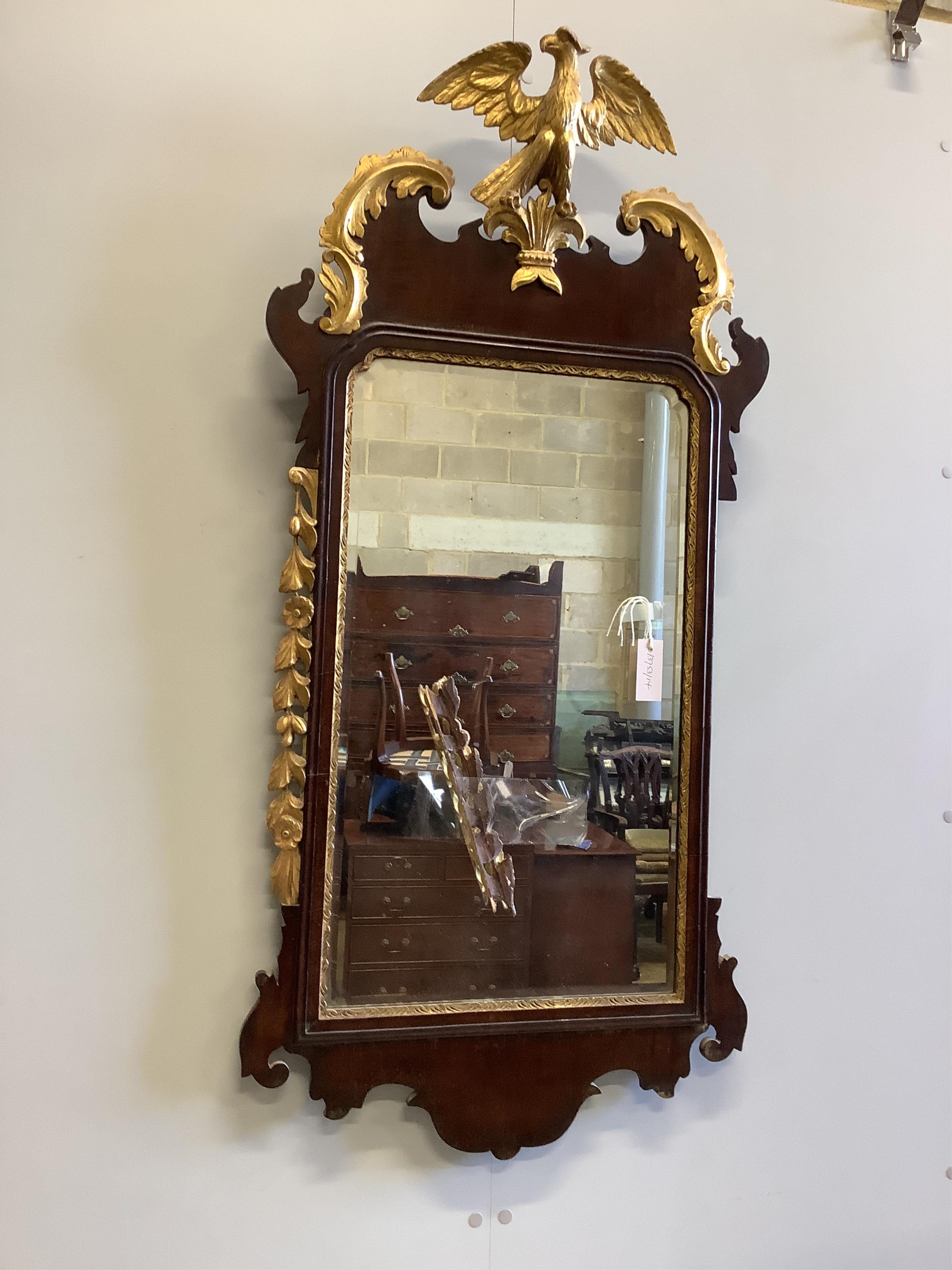 An early 19th century Chippendale design mahogany and parcel gilt fret carved pier glass, having carved eagle surmount between twin scrolled pediment and with foliage carved mount, width 57cm, height 120cm. Condition - p